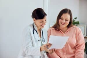 Happy, overweight woman having a consultation with her doctor to create a personalized weight loss plan.