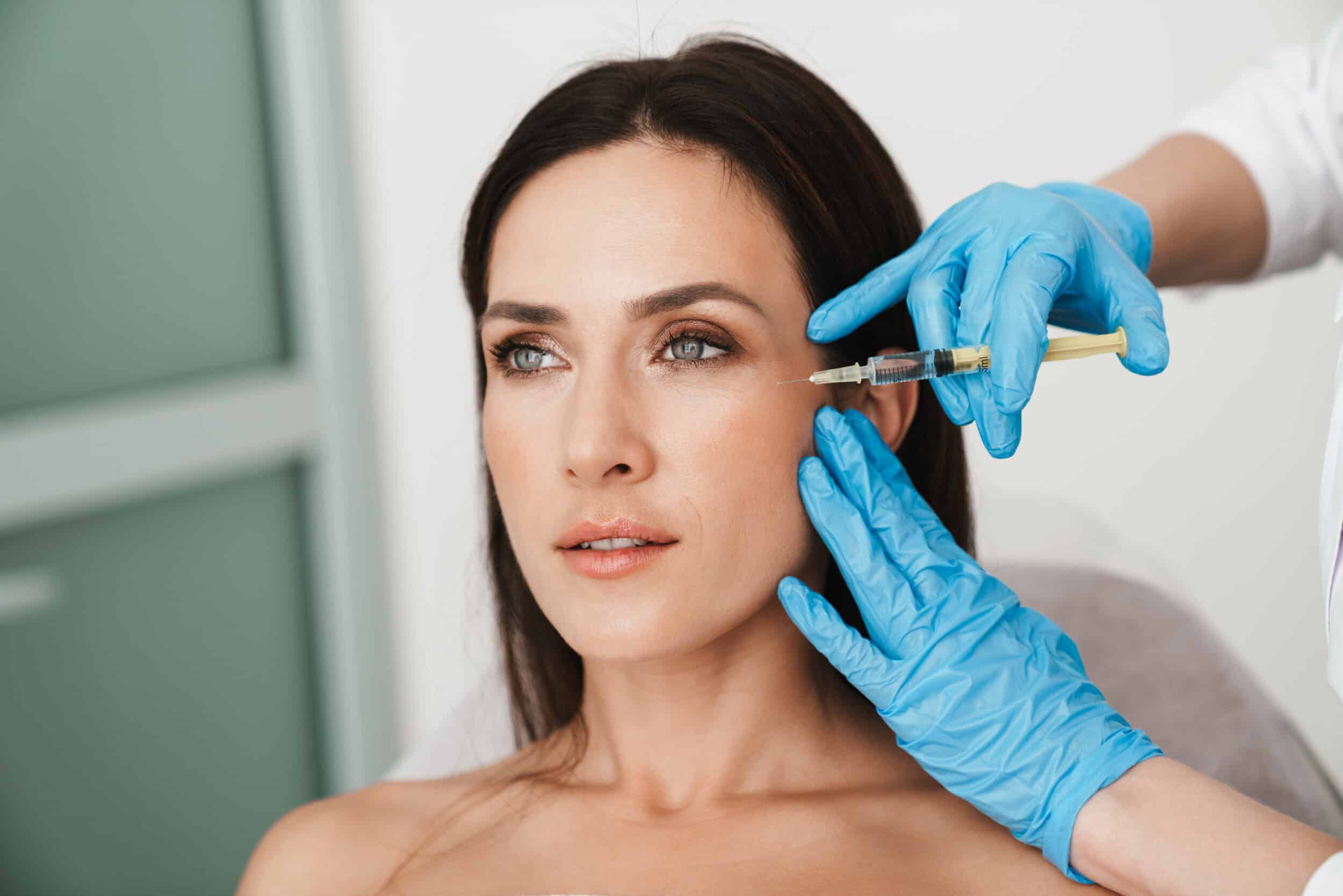 Beautiful middle-aged woman getting Botox injections to her forehead to prevent wrinkles and reduce signs of aging