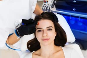 Woman receiving a relaxing Hydrafacial treatment from her provider in a spa-like setting