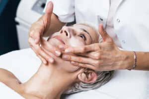 Senior woman having a chemical peel applied in a spa like setting.