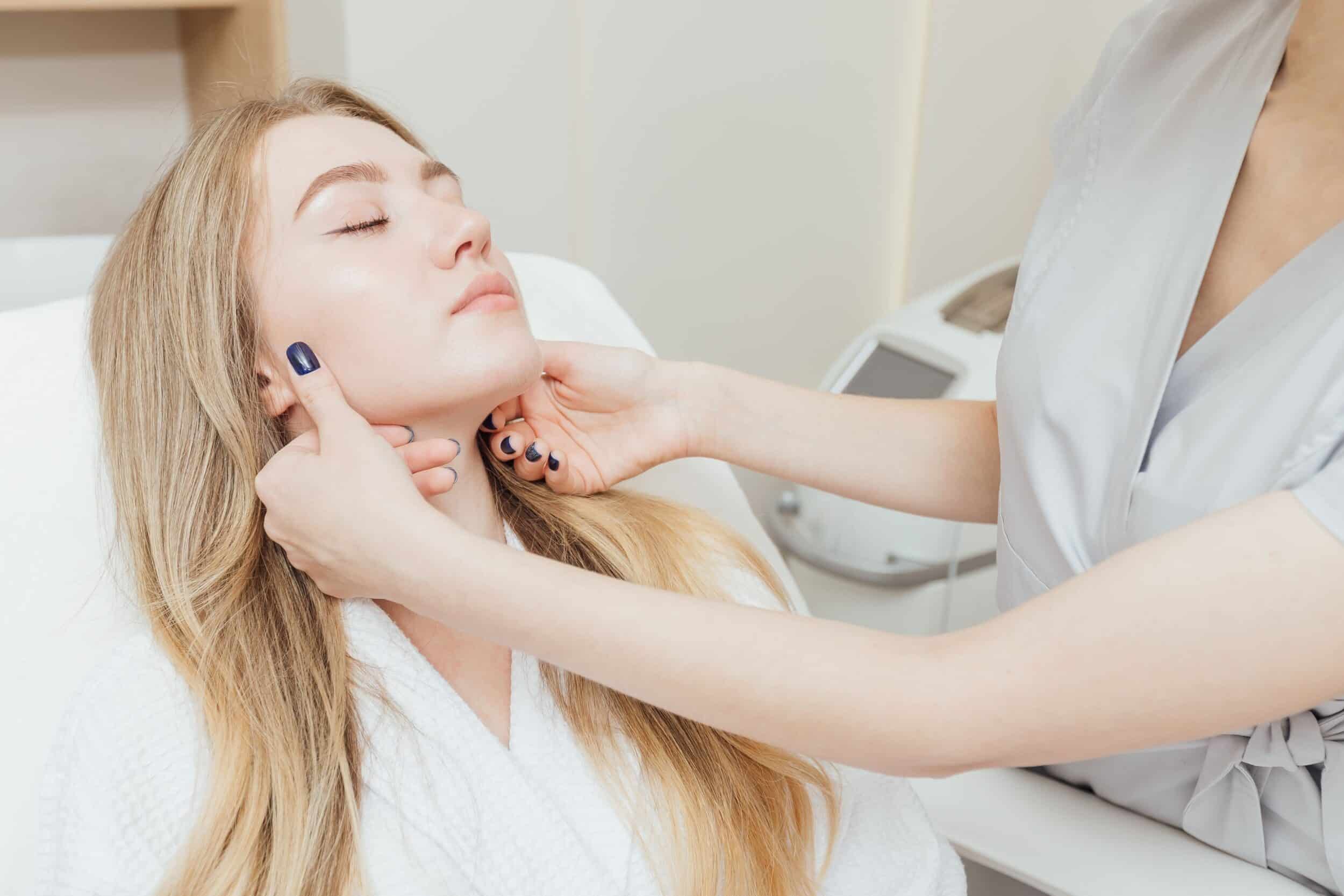 Beautiful young woman having her face evaluated during a spa facial treatment.