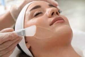 Close-up of a young woman having a chemical peel applied to her face for smoother, more radiant skin.